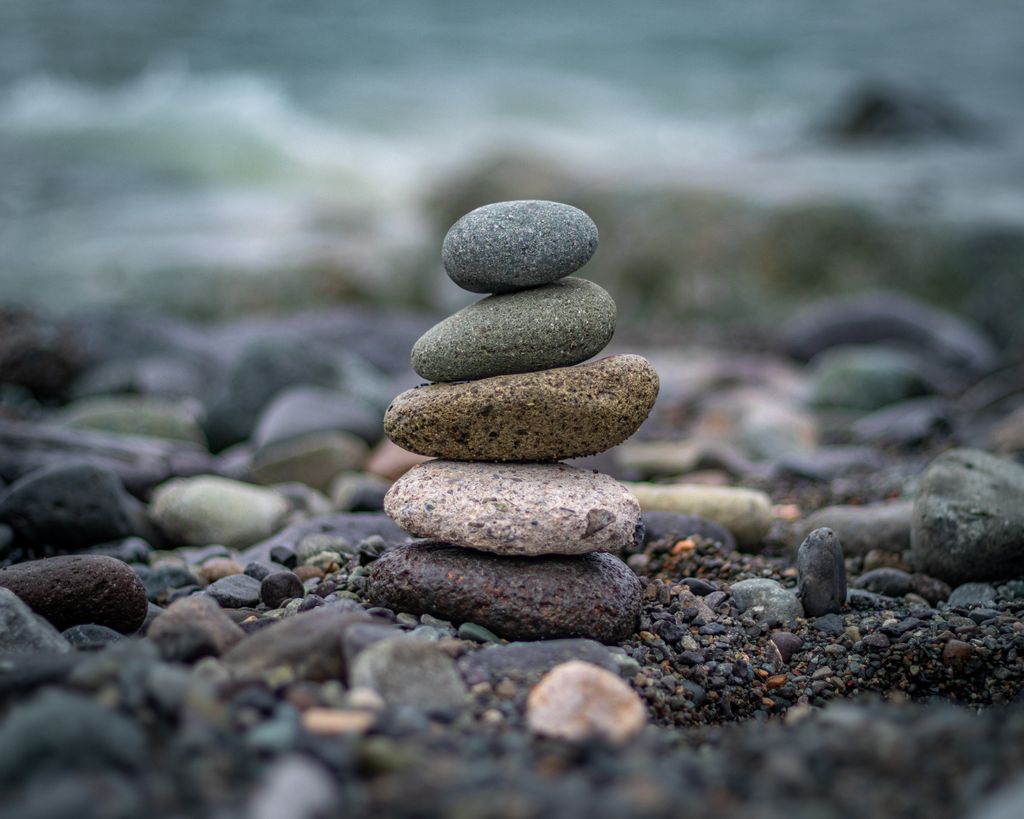A serene stack of balanced stones with a sea backdrop, symbolizing harmony and balance.